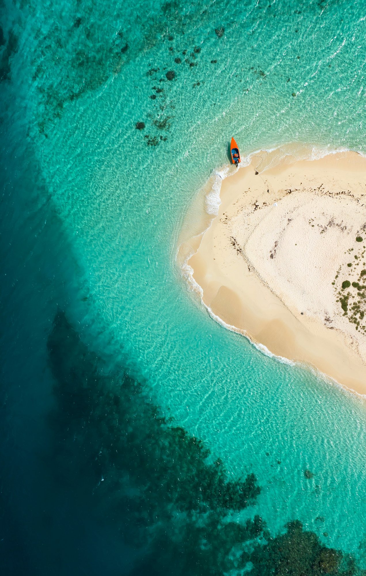 Aerial view of a white sand cay in clear turquoise water off Grenada