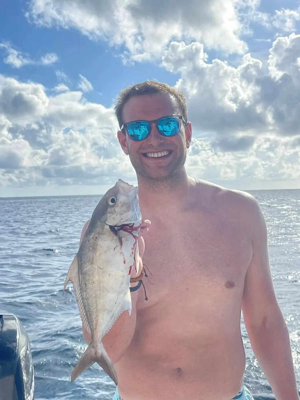 A guest holding a fresh catch aboard Epiphany