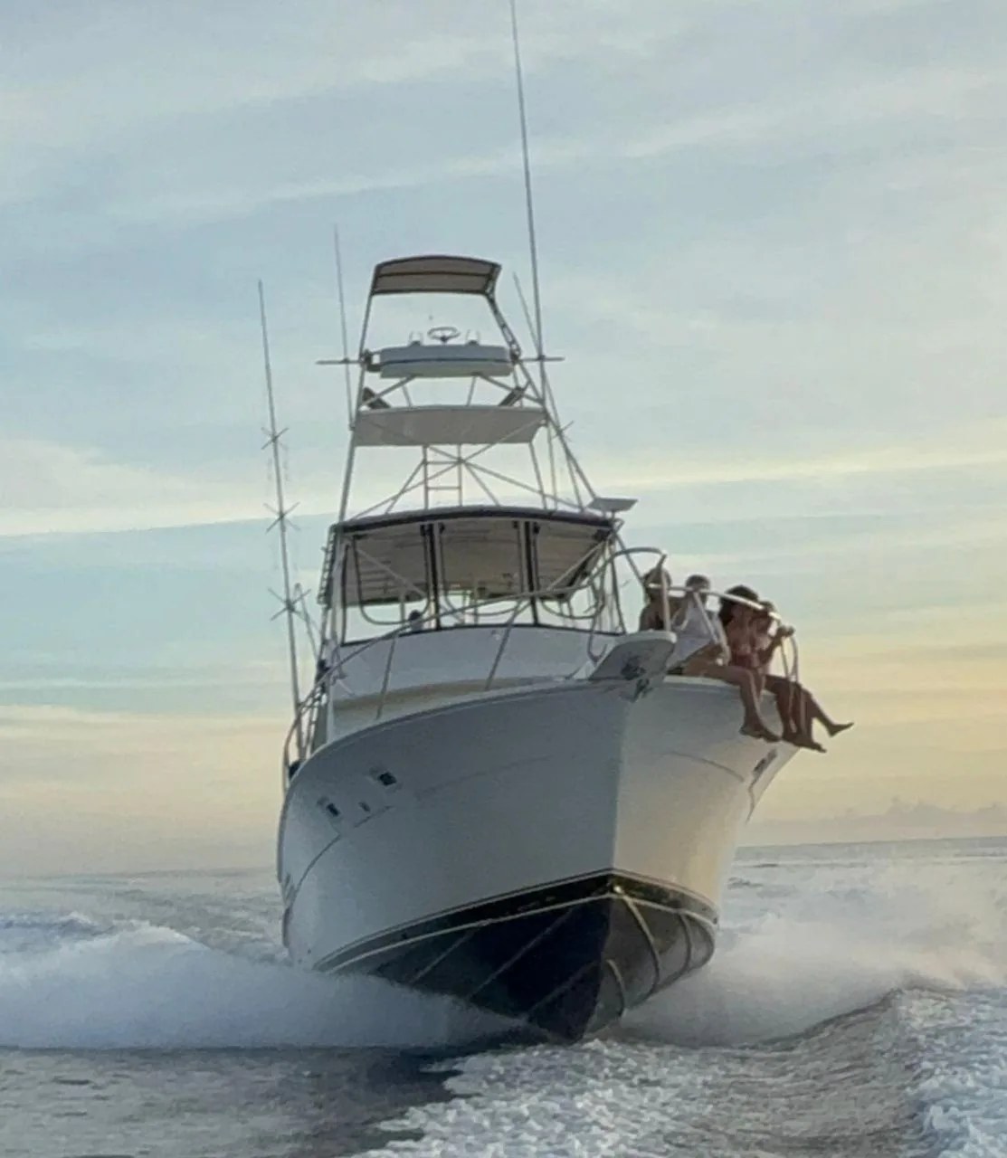 The Lucky Strike running at speed with guests on the bow at sunset