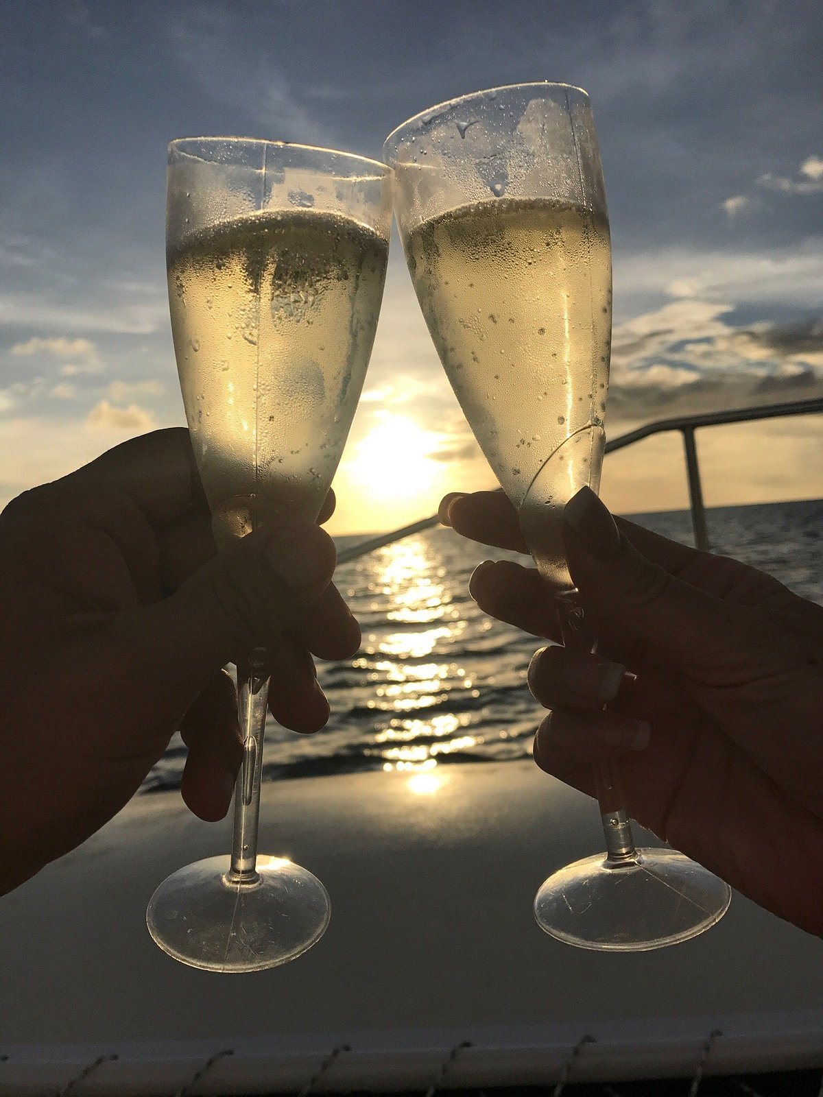 Two glasses of champagne raised at sunset aboard Shadowfax