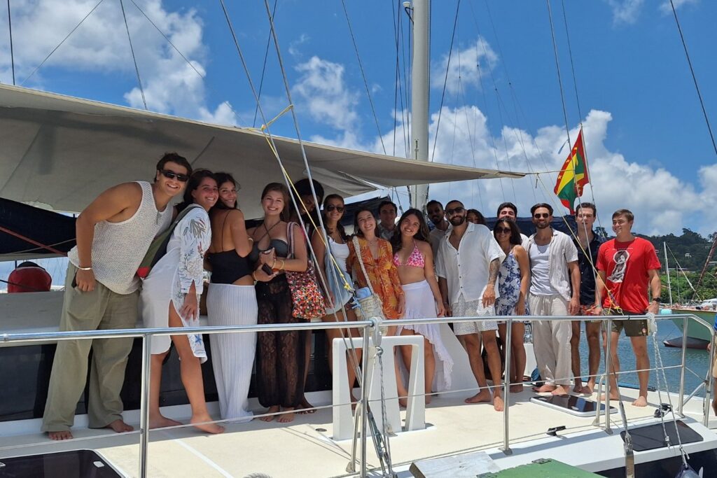 A group of guests on the deck of Shadowfax with the Grenadian flag flying