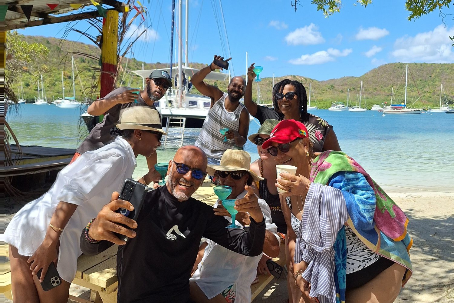 Guests raising a toast on the beach after a Shadowfax sailing