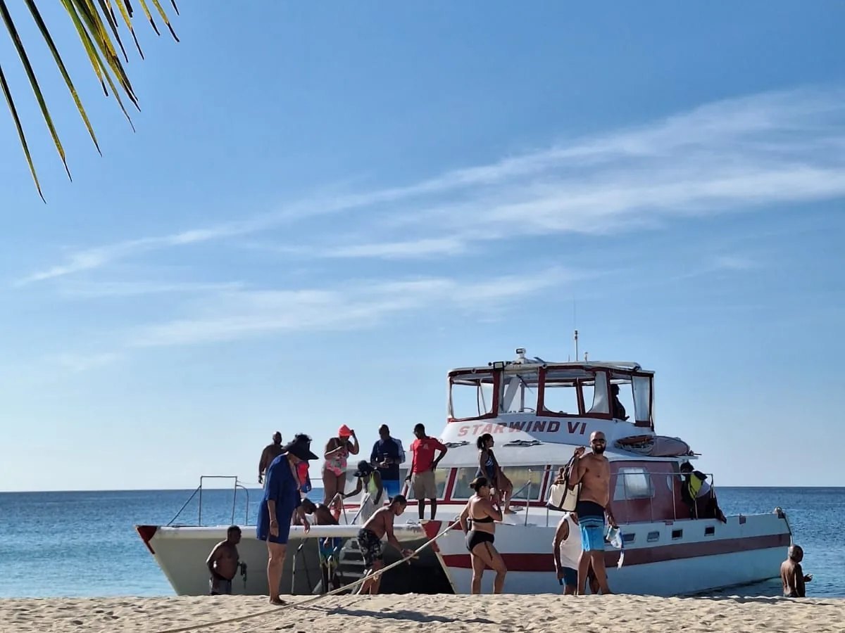 Guests stepping off Starwind VI onto a Grenada beach